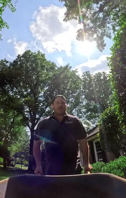 Landscaping employee pushing a wheelbarrow full of mulch in Charlotte, NC.
