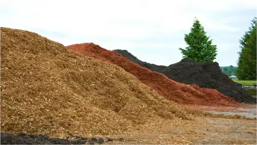 Various types of mulch and pine straw piles available for landscaping in Charlotte.